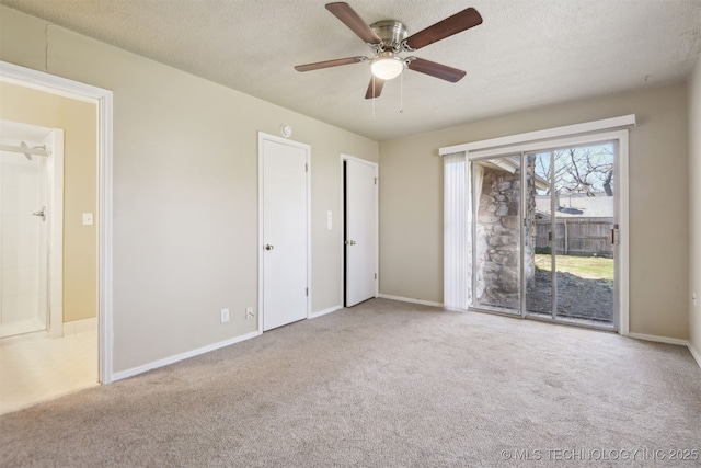 empty room featuring baseboards, a textured ceiling, a ceiling fan, and carpet floors