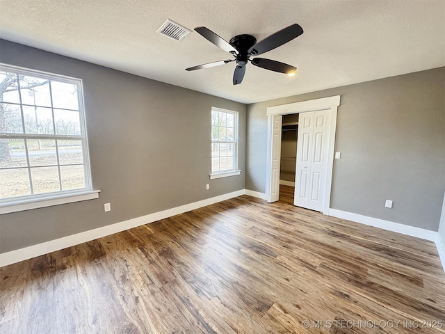 17022 S 579th Rd, Tahlequah, OK 74464 - unfurnished bedroom with wood finished floors, a closet, a ceiling fan, and a textured ceiling