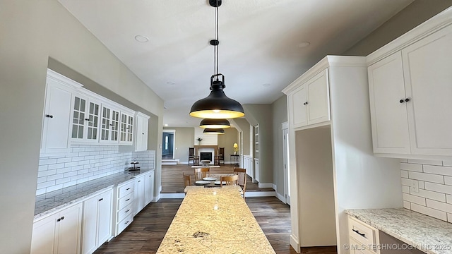17022 S 579th Rd, Tahlequah, OK 74464 - kitchen featuring tasteful backsplash, white cabinetry, glass insert cabinets, dark wood-type flooring, and decorative light fixtures