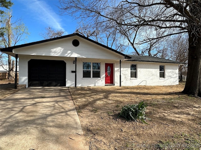 ranch-style house featuring concrete driveway, brick siding, and a garage