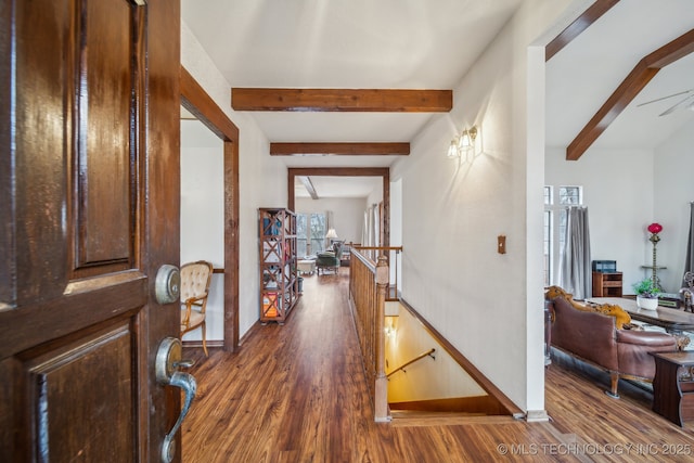 foyer entrance with dark wood finished floors, baseboards, and beam ceiling