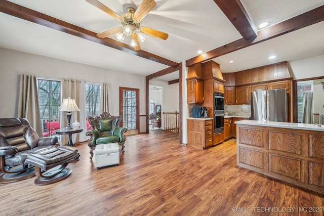 living area with light wood-style flooring, beam ceiling, recessed lighting, and a ceiling fan