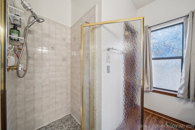 full bath with wood finished floors and a shower stall