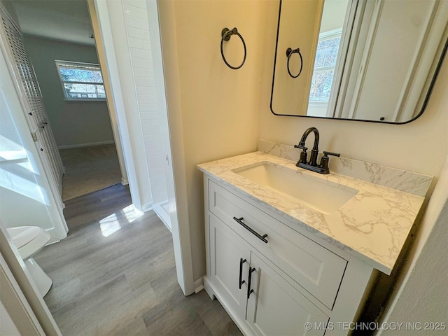 4760 S Irvington Ave, Tulsa, OK 74135 - bathroom with vanity, baseboards, and wood finished floors