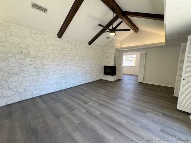4760 S Irvington Ave, Tulsa, OK 74135 - unfurnished living room with visible vents, dark wood-type flooring, ceiling fan, lofted ceiling with beams, and a stone fireplace