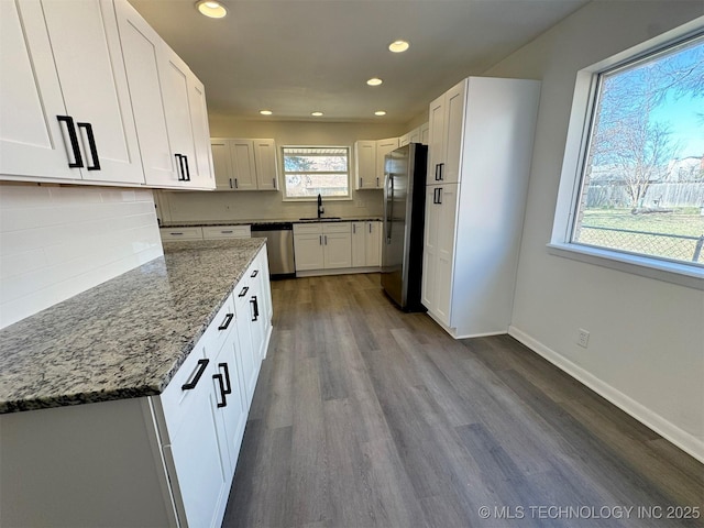 4760 S Irvington Ave, Tulsa, OK 74135 - kitchen featuring a sink, backsplash, stone counters, appliances with stainless steel finishes, and dark wood-style flooring