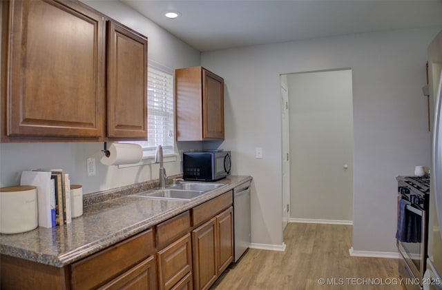 46 S 188th E Ave, Tulsa, OK 74108 - kitchen featuring a sink, light wood-type flooring, appliances with stainless steel finishes, and brown cabinetry