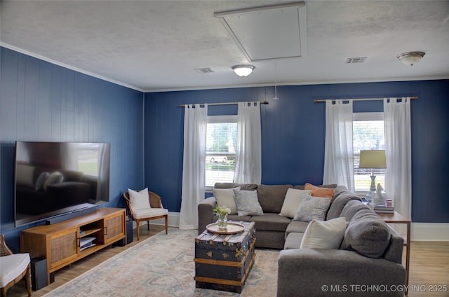 46 S 188th E Ave, Tulsa, OK 74108 - living area with attic access, wood finished floors, visible vents, and a wealth of natural light