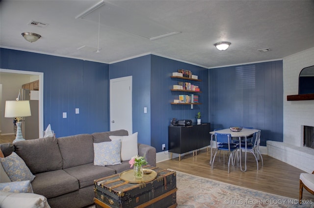 46 S 188th E Ave, Tulsa, OK 74108 - living area with visible vents, a brick fireplace, crown molding, attic access, and wood finished floors
