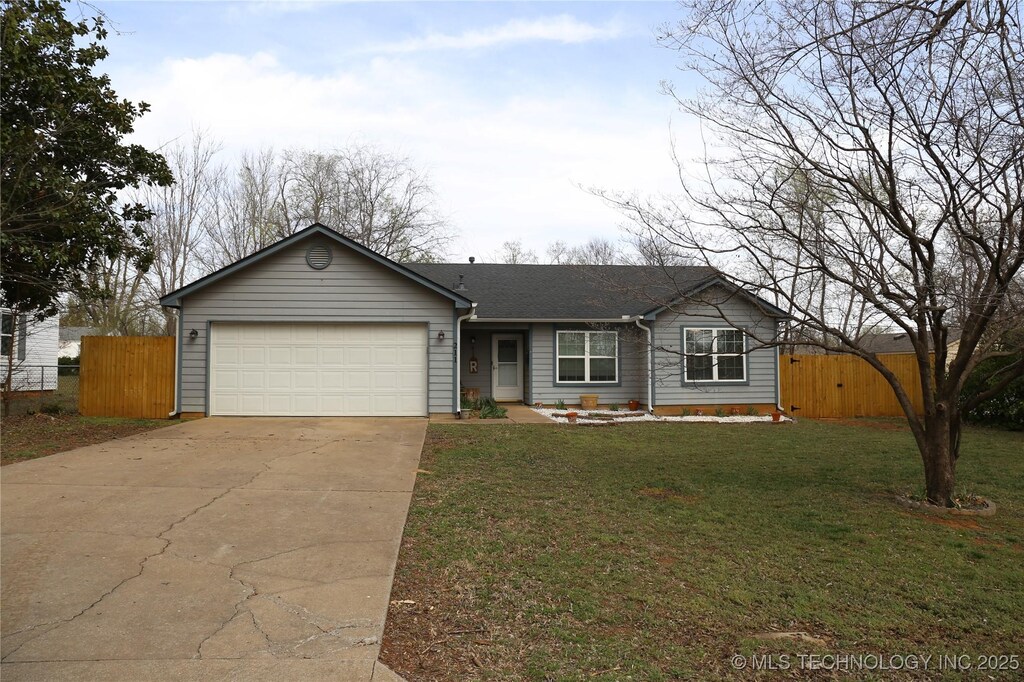 211 W 43rd St, Sand Springs, OK 74063 - ranch-style house featuring a front lawn, an attached garage, fence, and driveway