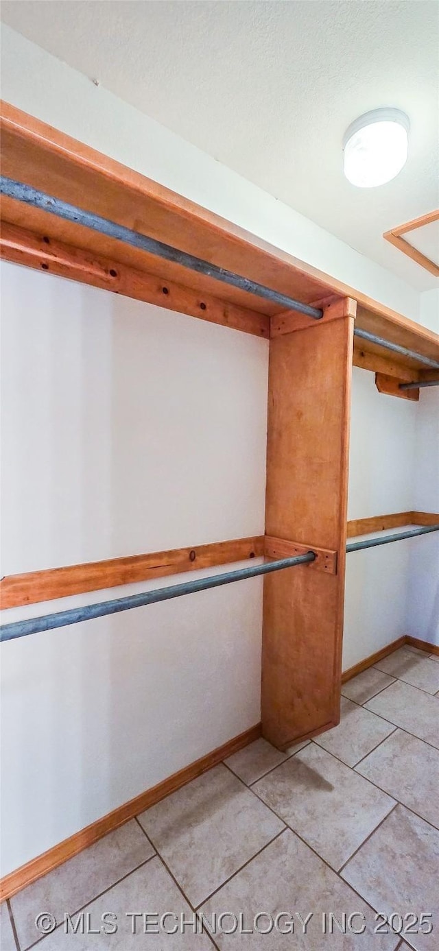 walk in closet with light tile patterned floors