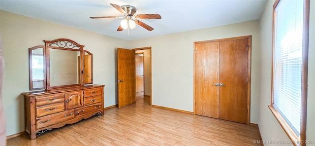 bedroom featuring a closet, light wood-style flooring, baseboards, and ceiling fan