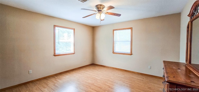unfurnished room featuring baseboards, light wood-style floors, and ceiling fan