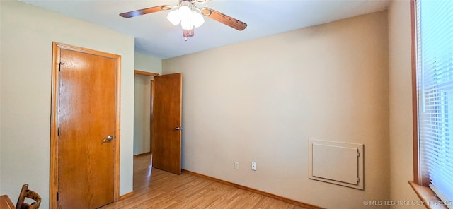 unfurnished bedroom with light wood-style flooring, a ceiling fan, and baseboards