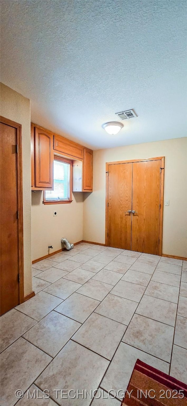 kitchen with visible vents, a textured ceiling, and baseboards