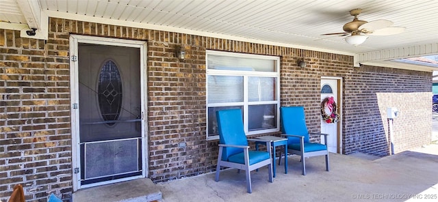 doorway to property featuring brick siding and ceiling fan