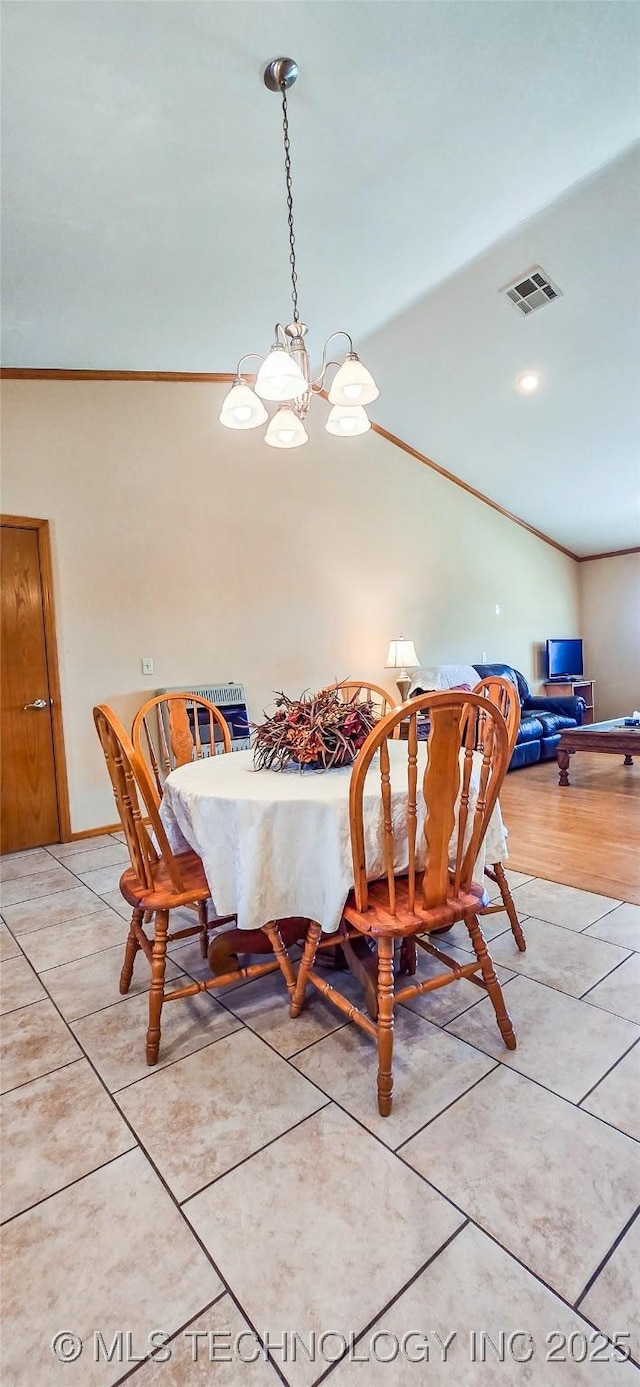 dining room with light tile patterned floors, visible vents, lofted ceiling, and ornamental molding