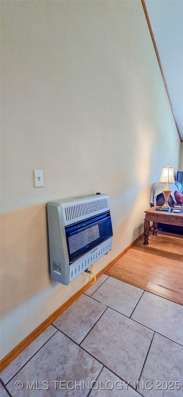 details with heating unit, wood finished floors, and baseboards