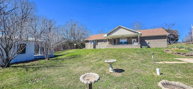 ranch-style house with brick siding, ceiling fan, and a front lawn