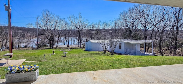 view of yard with an outbuilding and a wooded view