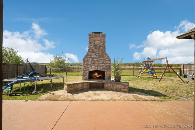 1946 E 135th St S, Bixby, OK 74008 - view of patio / terrace with a trampoline, an outdoor stone fireplace, and a playground