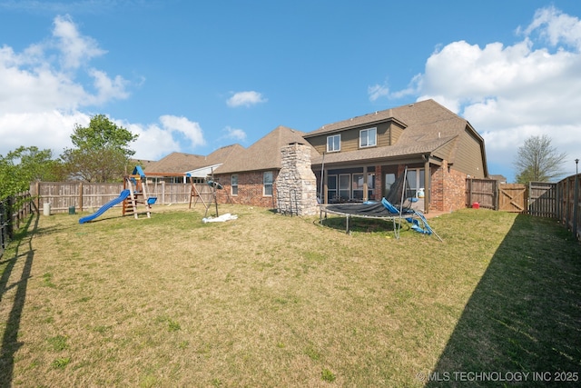 1946 E 135th St S, Bixby, OK 74008 - back of property with a trampoline, a playground, brick siding, and a gate