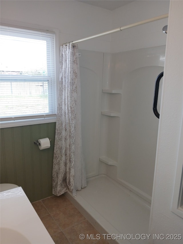 full bathroom with tile patterned floors and a shower with shower curtain
