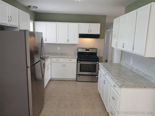 kitchen featuring white cabinetry, under cabinet range hood, light tile patterned floors, and stainless steel appliances