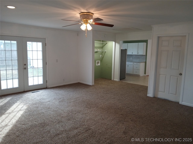 interior space featuring ceiling fan, french doors, crown molding, and light carpet