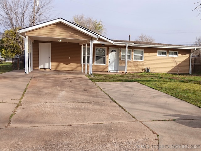 ranch-style house with driveway, a carport, fence, and a front lawn