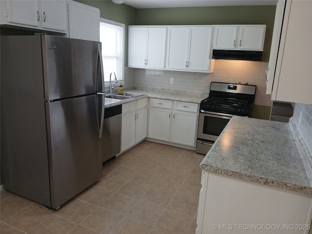 kitchen with white cabinetry, tasteful backsplash, under cabinet range hood, a sink, and appliances with stainless steel finishes