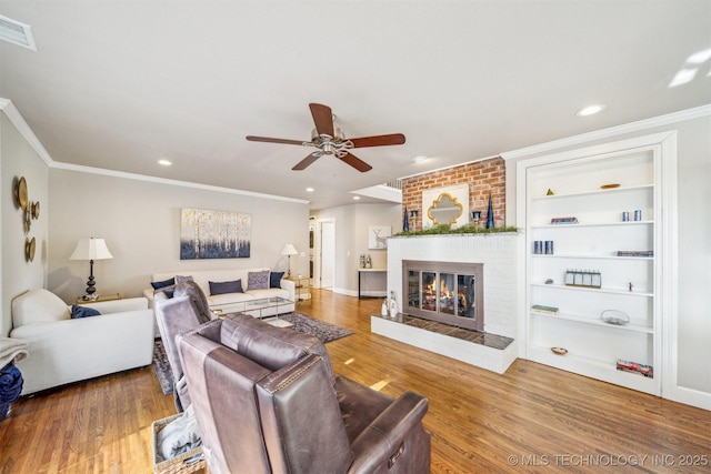 122 Osage Ridge Dr, Sand Springs, OK 74063 - living area featuring a brick fireplace, wood finished floors, visible vents, and ceiling fan