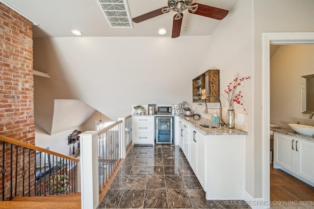 122 Osage Ridge Dr, Sand Springs, OK 74063 - kitchen with ceiling fan, a sink, wine cooler, white cabinets, and stainless steel microwave