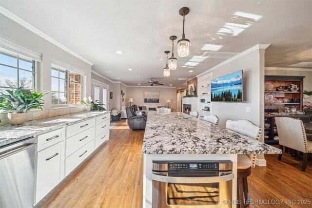 122 Osage Ridge Dr, Sand Springs, OK 74063 - kitchen with stainless steel dishwasher, white cabinets, light wood-style flooring, and open floor plan