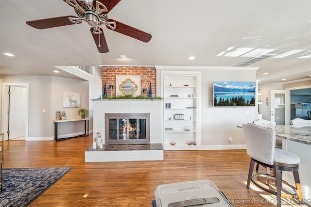122 Osage Ridge Dr, Sand Springs, OK 74063 - living room featuring visible vents, baseboards, built in features, wood finished floors, and a ceiling fan