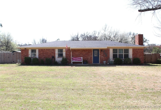 ranch-style home featuring a chimney, a front yard, fence, and brick siding