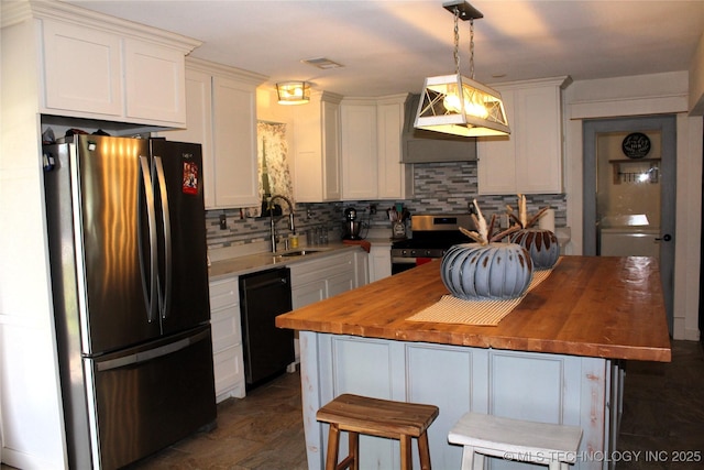 kitchen featuring stainless steel electric range oven, wood counters, dishwasher, a sink, and freestanding refrigerator