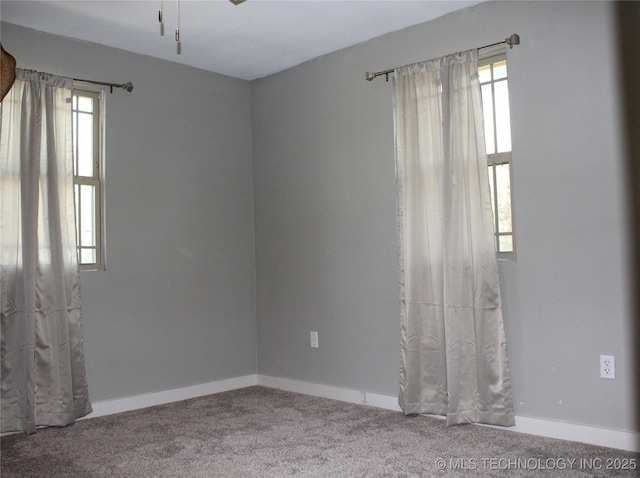 carpeted spare room featuring baseboards and ceiling fan
