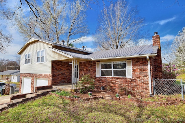 1004 S Owens Ave, Tahlequah, OK 74464 - split level home featuring metal roof, an attached garage, brick siding, and a chimney