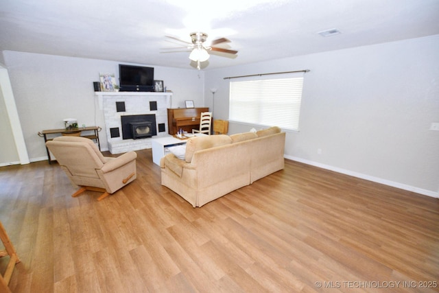 1004 S Owens Ave, Tahlequah, OK 74464 - living room with ceiling fan, a brick fireplace, light wood-style floors, and baseboards