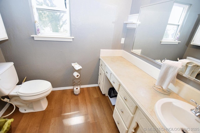 1004 S Owens Ave, Tahlequah, OK 74464 - bathroom with wood finished floors, toilet, vanity, and baseboards