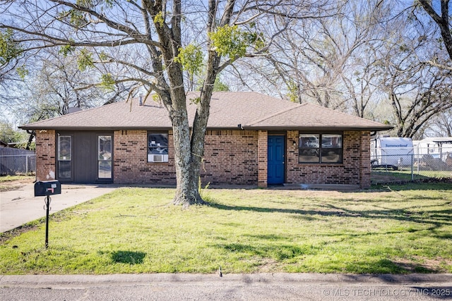 ranch-style house with brick siding, roof with shingles, a front yard, and fence
