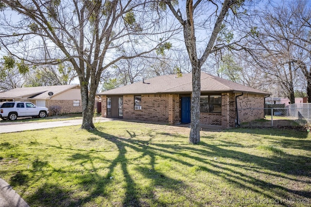 single story home with a front lawn, fence, brick siding, and a shingled roof