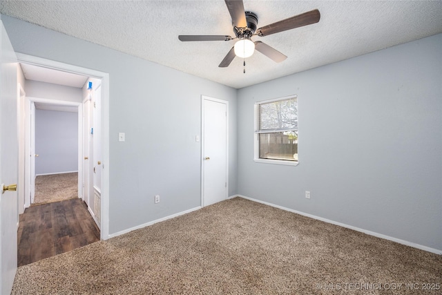 unfurnished bedroom featuring baseboards, carpet floors, and a textured ceiling