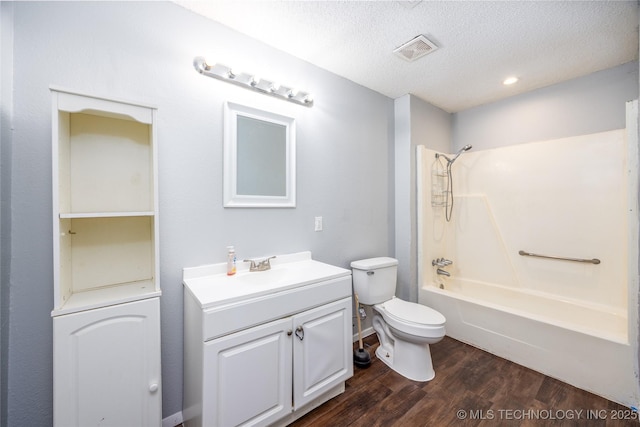 full bath with visible vents, toilet, a textured ceiling, wood finished floors, and shower / bathtub combination