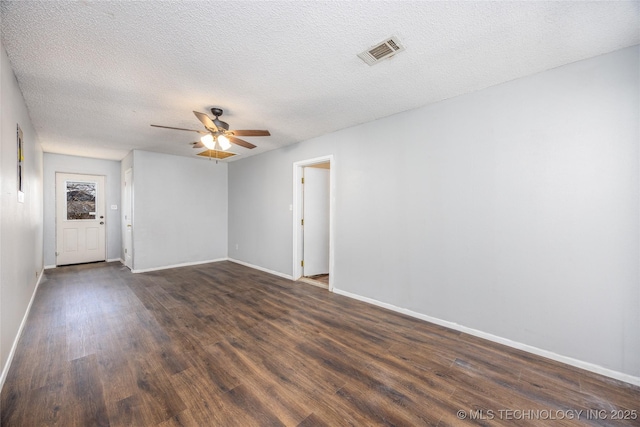 unfurnished living room with visible vents, baseboards, ceiling fan, dark wood-style floors, and a textured ceiling