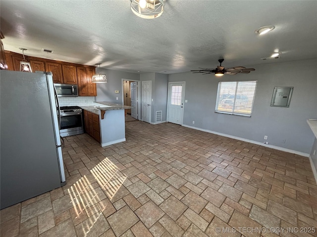 34 S Mount Calvary Rd, Hendrix, OK 74741 - kitchen with appliances with stainless steel finishes, a peninsula, a ceiling fan, baseboards, and brown cabinetry