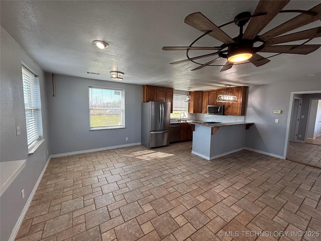 34 S Mount Calvary Rd, Hendrix, OK 74741 - kitchen with stainless steel appliances, a sink, a peninsula, baseboards, and a kitchen breakfast bar