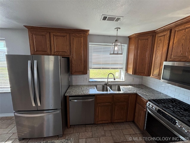34 S Mount Calvary Rd, Hendrix, OK 74741 - kitchen featuring appliances with stainless steel finishes, stone tile flooring, tasteful backsplash, a sink, and a textured ceiling