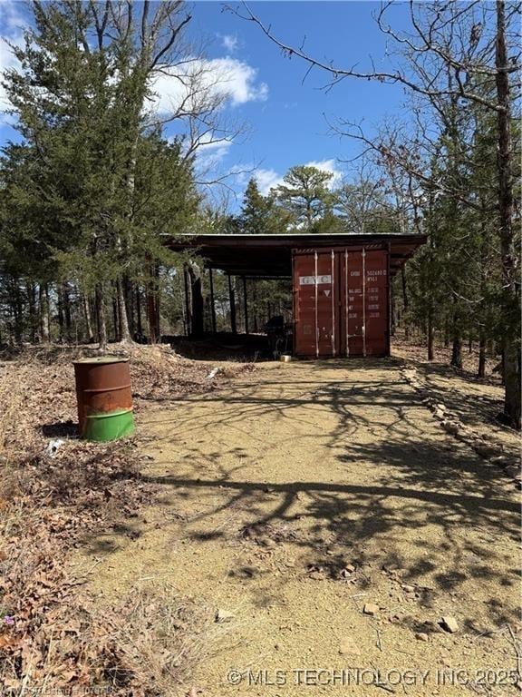 exterior space with an attached carport and an outdoor structure